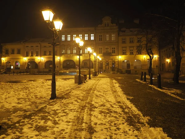 Главная площадь в центре города Бельско-Бяла в Польше со старыми зданиями, уличными фонарями и снегом вечером — стоковое фото