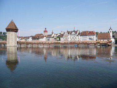 LUCERNE, AĞUSTOS 2018: Temsilci tarihi binalar, şapel köprüsü ve Reuss nehrindeki muhteşem Avrupa şehir manzaraları, güneşli yaz gününde açık mavi gökyüzü.