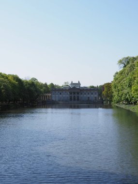 Avrupa 'nın başkenti Varşova' daki Hamamlar Parkı 'ndaki gölün kıyısındaki sarayda 2019' da açık mavi gökyüzü Mayıs ayında güneşli bir bahar sabahı - dikey.