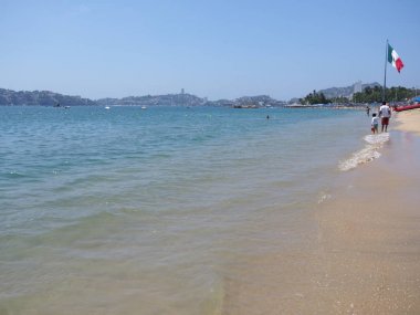 Pasifik Okyanusu'nda Meksika Acapulco şehir koyunda büyük Meksika ulusal bayrağı ve şezlong ile pitoresk manzara