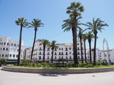 Fas'ın Tetouan şehir merkezinde Moulay el Mehdi de kavşak üzerinde beyaz binalar ve palmiye ağaçları ile Kare