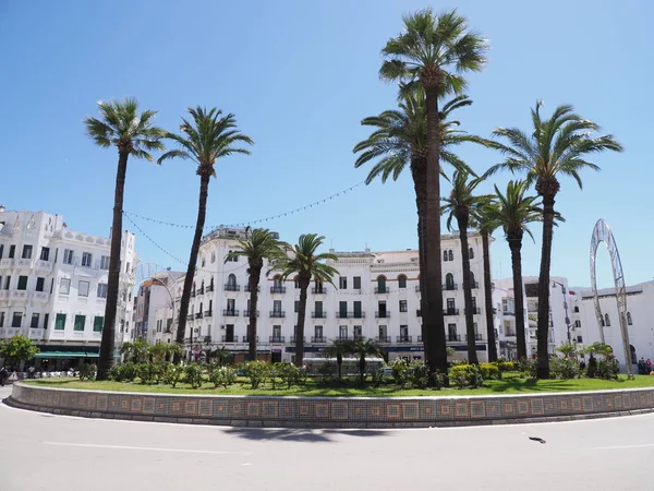 Fas'ın Tetouan şehir merkezinde Moulay el Mehdi de kavşak üzerinde beyaz binalar ve palmiye ağaçları ile Kare