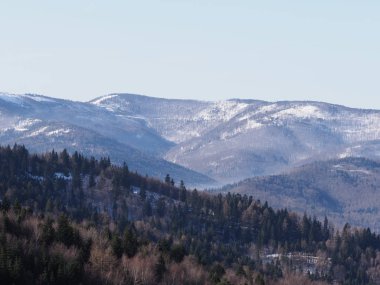 Polonya 'nın Bielsko-Biala kenti yakınlarındaki Batı Karpatlar' daki Silezya Beskids dağlarına bakan manzara 2019 yılının soğuk ve güneşli kış gününde açık mavi gökyüzü.