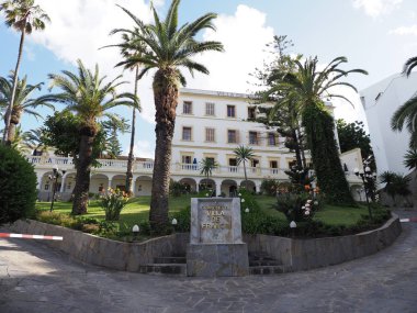 TANGIER, MOROCCO on APRIL 2019: White hotel building and palm trees in african city with cloudy blue sky in warm sunny spring day.