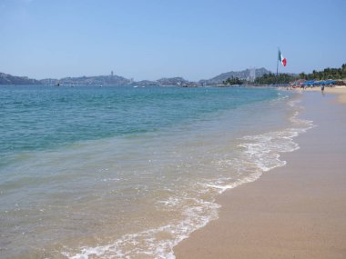 Meksika ve Pasifik Okyanusu manzara Acapulco Şehir Körfezi 'nde büyük Meksika Ulusal bayrağı ile panoramik turkuaz dalgalar