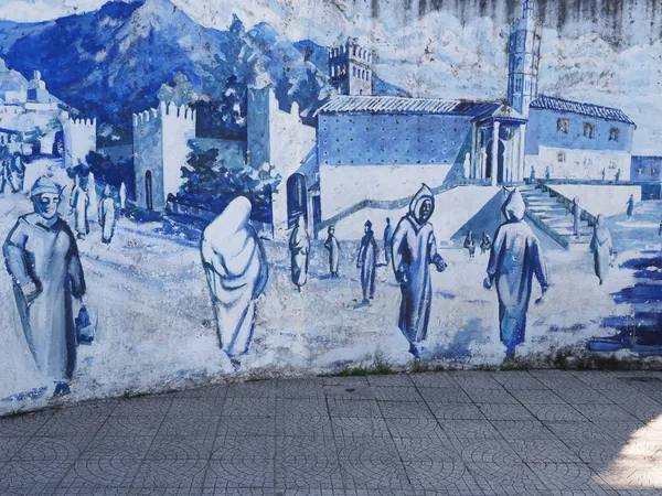 Sıcak güneşli yaz gününde Fas Afrika Chefchaouen kasabasında orta meydanda sokakta duvarda Resim. — Stok fotoğraf