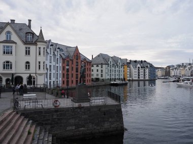 Avrupa 'daki liman ve ayrılıkçı oteller Romsdal bölgesindeki suya yansıdı ve sıcak bir yaz akşamı bulutlu bir gökyüzü oluştu..