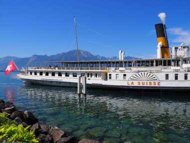 MONTREUX, SWitness ZERLAND HAZİRAN 2017: Paddle-wheel buharlı tekne Avrupa 'nın Vaud kantonundaki Cenevre Gölü' nde gezinmeye hazır, güneşli yaz gününde açık mavi gökyüzü.