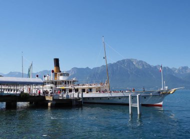 MONTREUX, SWitness ZERLAND HAZİRAN 2017: Paddle-wheel buharlı tekne Avrupa 'nın Vaud kantonundaki Cenevre Gölü' nde gezinmeye hazır, güneşli yaz gününde açık mavi gökyüzü.