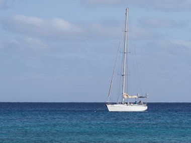 White yacht on clear turquoise waters of Atlantic Ocean landscapes at african Sal island in Cape Verde, horizon line and clear blue sky in 2019 warm sunny summer day on March.