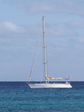 Yacht on clear turquoise waters of Atlantic Ocean landscapes at african Sal island in Cape Verde, horizon line and clear blue sky in 2019 warm sunny summer day on March - vertical.