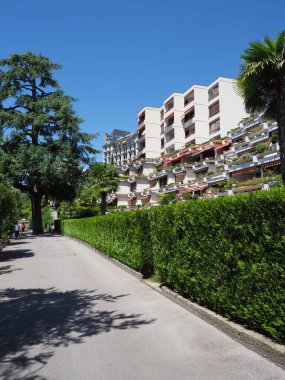İsviçre 'de Vaud Kantonu' ndaki Avrupa Montreux şehrindeki gezinti güvertesindeki binalar, Temmuz 'da sıcak ve güneşli 2017' de açık mavi gökyüzü - dikey.