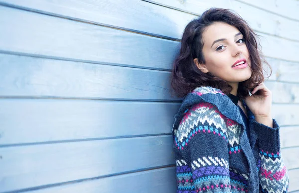 木製の背景に対してポーズ暖かいウール セーターの若い陽気な女性 — ストック写真