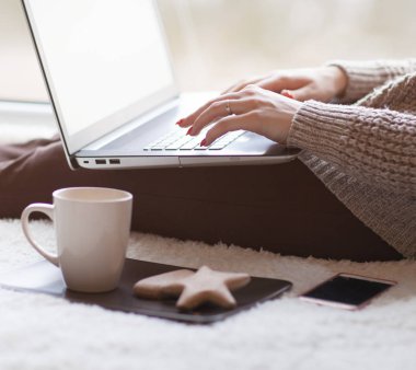 Dizüstü bilgisayarda çalışan ve kakao içme kadın görünümü Kapat