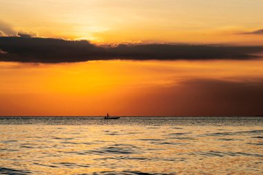 Balıkçılar güzel bir günbatımında balık yakalar.