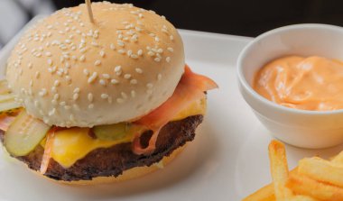 Burger bir tabak kızarmış patates ve sos ile