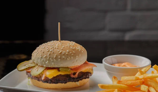 Burger auf einem Teller mit Bratkartoffeln und Sauce — Stockfoto