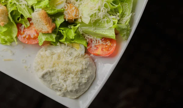 Salada Caesar em uma placa branca e um fundo de vidro — Fotografia de Stock