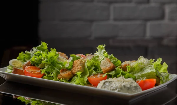 Sezar salatası beyaz bir tabak ve cam arka plan — Stok fotoğraf