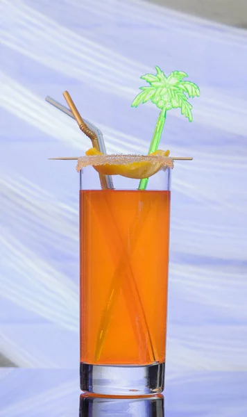 Glas met een cocktail op een glazen tafel en een baksteen-achtergrond — Stockfoto