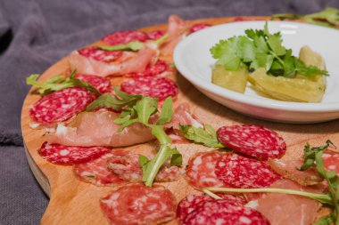 Yeşiller ve salatalık tahta kaşıkla sosis kesti