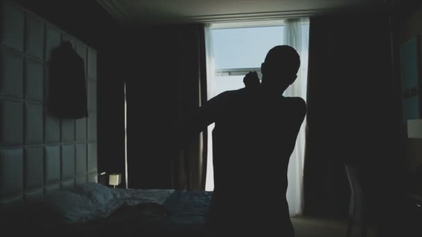 Бізнесмен одягає піджак біля вікна — стокове відео