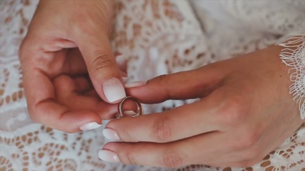 Un anillo en la mano de una chica que lo mira — Vídeos de Stock