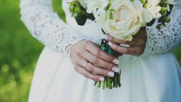 Verliefde paar bedrijf een bruiloft boeket in handen — Stockvideo