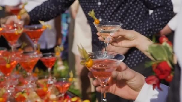 The guests hands take glasses with bubbling wine at the party. Glasses are built in the pyramids. No recognizable persons — Stock Video