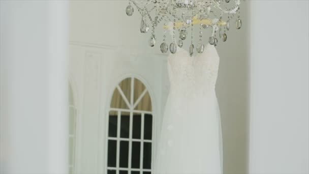 Brudklänning hängande i ett vitt vackert rum — Stockvideo
