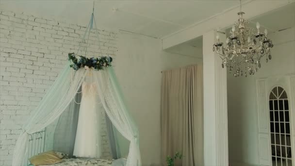 Весільна сукня висить у білій красивій кімнаті — стокове відео