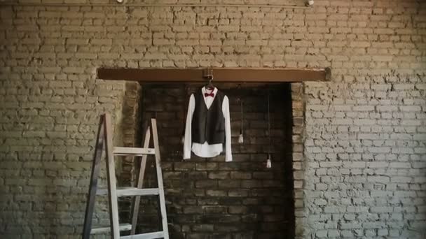 A mans jacka hänger på en galge på loft plats — Stockvideo