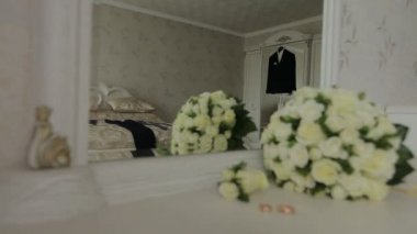 Bir ceket. Takım elbise kostüm askı odasında asılı. Ayna aracılığıyla hangi yalanlar üzerine bir demet gül ve yüzük görmek