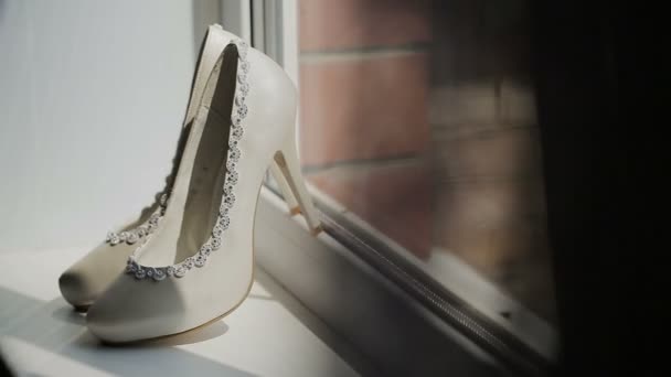 White shoes on the stiletto stand at the window — Stock Video