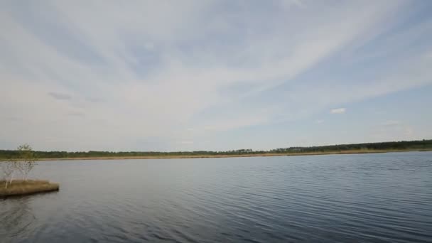 Lago desde la orilla contra un cielo azul — Vídeo de stock