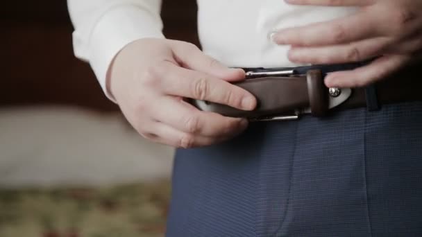 Groom puts belt on his pants in wedding morning — Stock Video