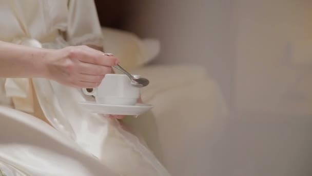 Eine Tasse Kaffee in den Händen eines schönen Mädchens am Morgen — Stockvideo