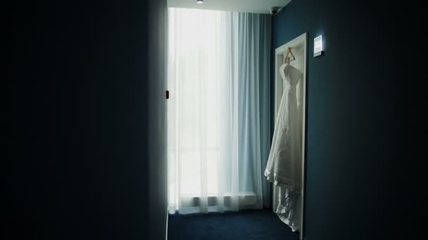 Vestido de novia colgando en una hermosa habitación blanca — Vídeos de Stock