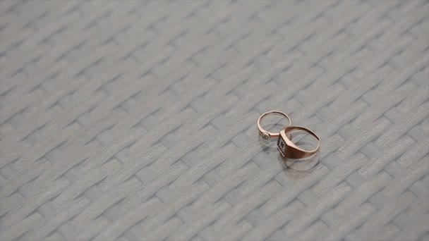 Anillos de boda girando con fondo texturizado — Vídeo de stock