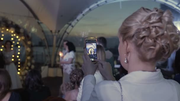 Het meisje opstijgt op de telefoon in de avond een ceremonie afsluiten — Stockvideo