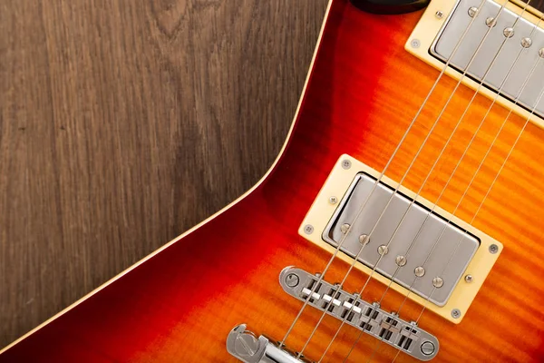 Stara piękna gitara elektryczna na tle drewna. — Zdjęcie stockowe