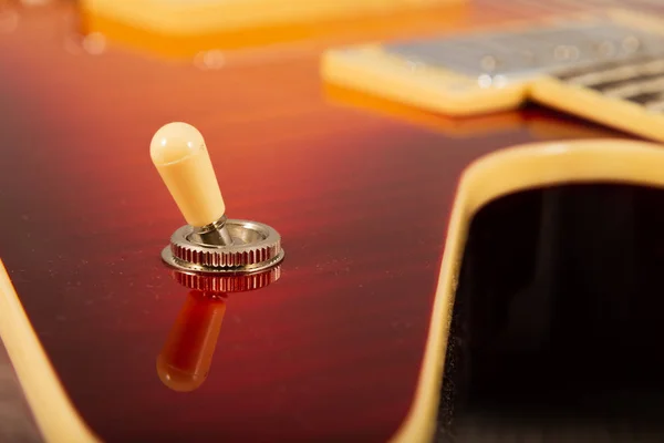 Oude mooie elektrische gitaar op een achtergrond van hout. — Stockfoto