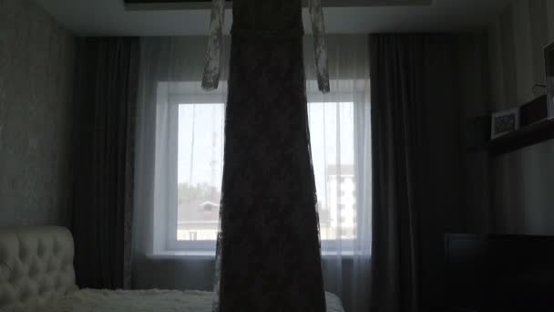 Vestido de noiva pendurado na frente da janela — Vídeo de Stock