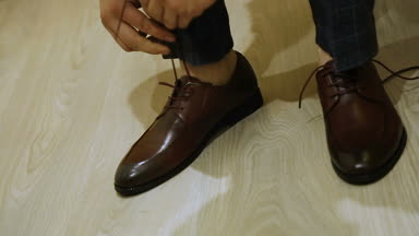 Bir adam kadar ayakkabı bağı bağlar