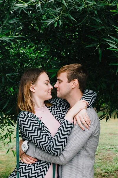 Two lovers walk around the park, kiss and hug, a love story. — Stock Photo, Image