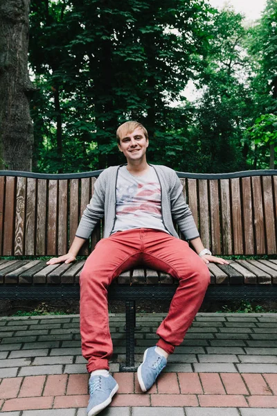 Porträtt av en snygg man på en bänk i parken. — Stockfoto
