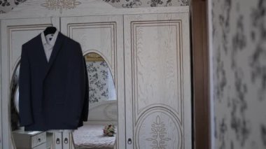 A mans bir askı odasında ceket asmak