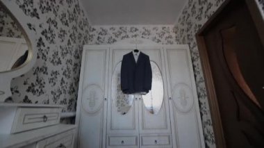 A mans bir askı odasında ceket asmak