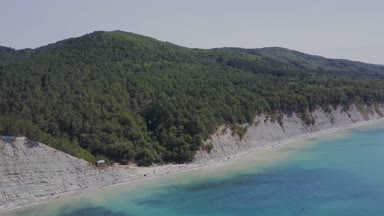 Uçuş vahşi plaj üzerinde. Dağlar ve kayalıklarla