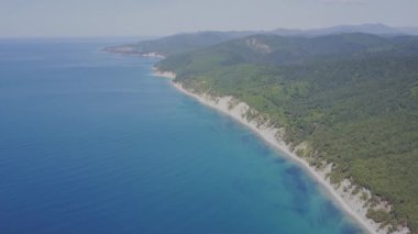 Uçuş vahşi plaj üzerinde. Dağlar ve kayalıklarla